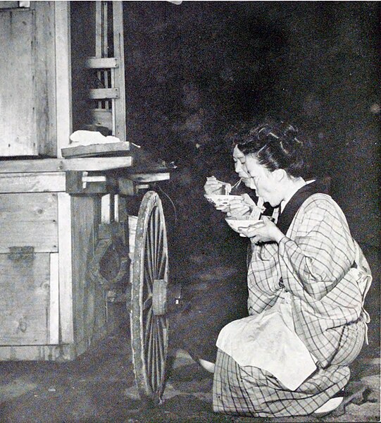 屋台でラーメンを食べる人の写真